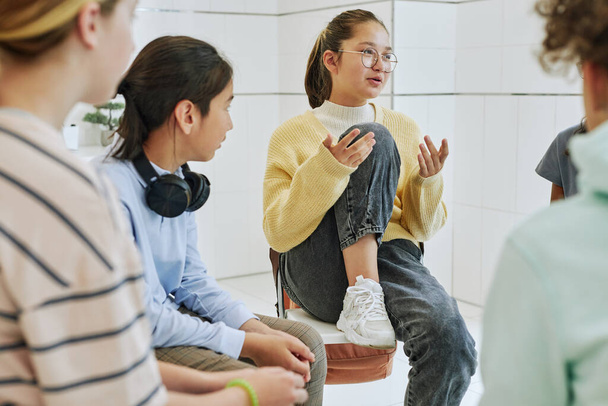Portrait of teenage girl sharing feelings in support group circle for children - Photo, Image