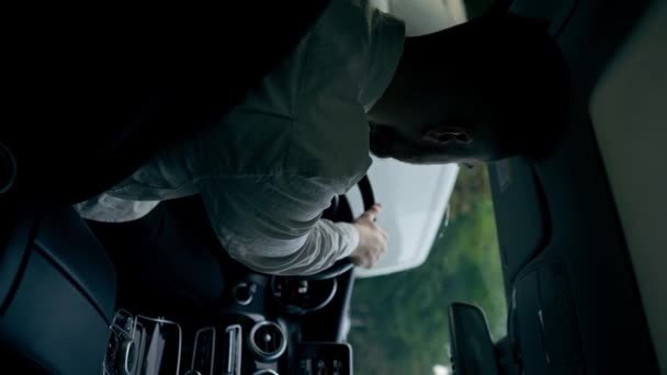 vertikale Video-Rückseite ein Mann ein Geschäftsmann fährt ein Luxusauto durch die Stadt ein schwarzes Leder Interieur Navigationsschirm Staus - Filmmaterial, Video