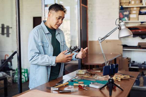 Porträt eines modernen Kunsthandwerkers, der Video-Tutorials in der Lederverarbeitung aufnimmt und kleine Unternehmen online fördert - Foto, Bild
