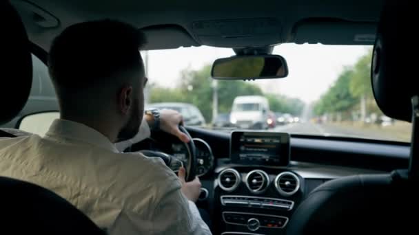 вид ззаду чоловік бізнесмен керує розкішним автомобілем навколо міста чорні шкіряні внутрішні навігаційні пробки на екрані - Кадри, відео