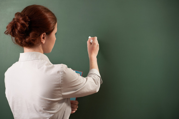 Girl writing on a chalkboard - Foto, imagen