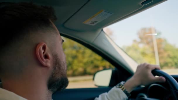 primer plano reflexivo conductor profesional serio centrado detrás del volante lleva a su pasajero el coche - Metraje, vídeo
