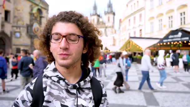 Prague, République tchèque, le 4 août 2023. Un jeune homme caucasien prend un selfie avec l'une des vues les plus belles et emblématiques la place de la vieille ville avec l'horloge astronomique et l'église en arrière-plan - Séquence, vidéo