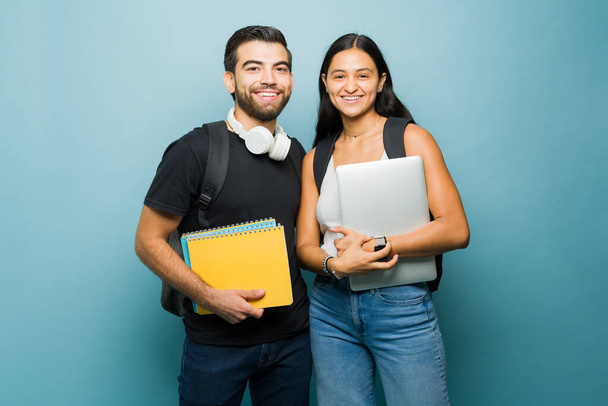 Atraktivní veselá mladá žena a muž a spolužáci z vysoké školy, kteří nosí své učebnice a vypadají šťastně   - Fotografie, Obrázek
