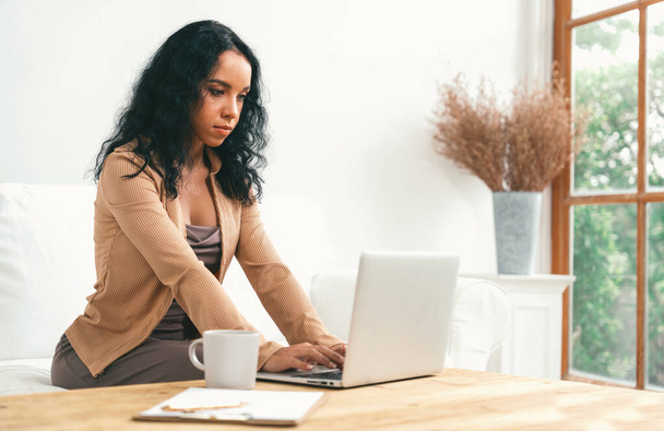 Afroamerikanerin nutzt Laptop für wichtige Arbeiten im Internet. Sekretärin oder Online-Content Schreiben zu Hause. - Foto, Bild