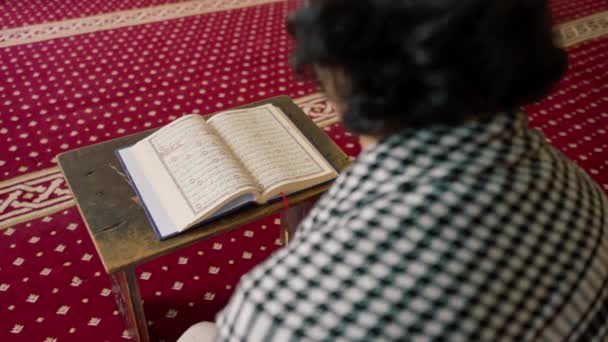Мусульманин сидить мовчки на килимі в святій мечеті молиться про Коран і звертається до Аллаха - Кадри, відео