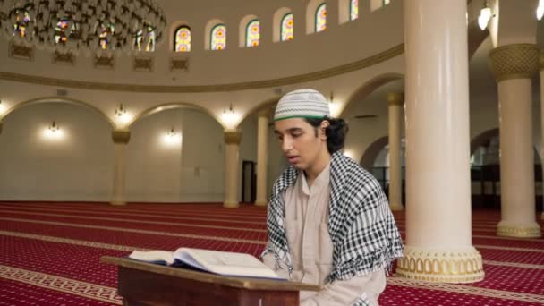 Мусульманин сидить мовчки на килимі в святій мечеті молиться про Коран і звертається до Аллаха - Кадри, відео