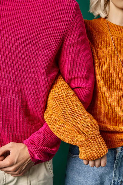 обрезанный вид молодых мужчин и женщин в вязаных зимних свитерах позируют вместе, зимняя мода - Фото, изображение