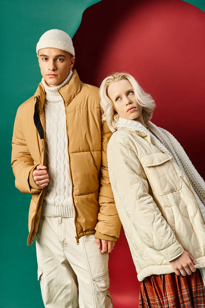 блондинка в білій зимовій куртці спирається на красивого чоловіка в Беані на червоному з бірюзовим тлом - Фото, зображення