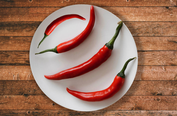 červené chilli papričky-červené chilli-červené chilli v talíři-papričky v talíři-červené chilli na talíři-červené chilli na stole - Fotografie, Obrázek