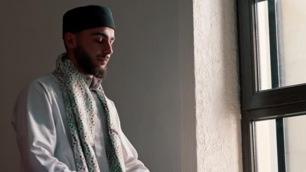 Porträt eines muslimischen Mannes, der im Ramadan auf Knien betet und in der Moschee für Unterstützung und spirituelles Wohlergehen dankt - Filmmaterial, Video