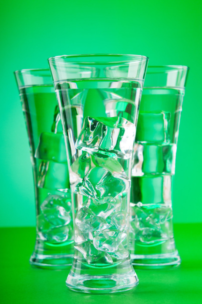 water in het glas tegen achtergrond met kleurovergang - Foto, afbeelding