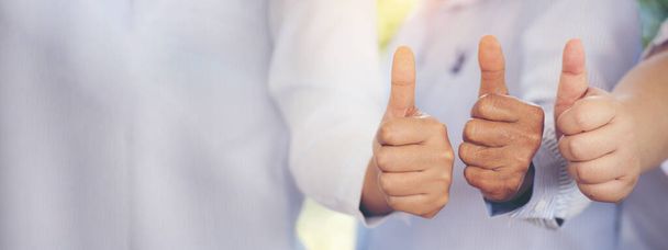 Banner Thumbs up team hand satisfaction job with positive happy good sign. Close up business people partner hand good sign. Panorama Teams trust Gesture Thumbs up together as teamwork with copy space - 写真・画像