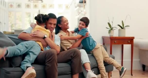 Familie umarmt, glücklich und plaudert auf dem Sofa mit Liebe, Sorgfalt und Zusammenhalt in einem gemeinsamen Haus. Aufgeregt, entspannt und junge Eltern mit Zuneigung zu Kindern und Gespräch auf der Wohnzimmercouch. - Filmmaterial, Video