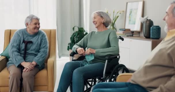 Rozmowa, szczęście i starsi przyjaciele w salonie domu opieki lub emerytury. Szczęśliwy, dyskusja i grupa starszych osób niepełnosprawnych rozmawiać w salonie razem w domu - Materiał filmowy, wideo