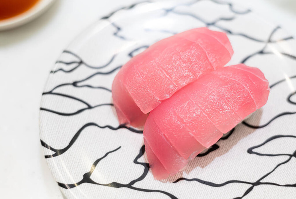 Gros plan des sushis chutoro sur une assiette en céramique blanche. Sushi cru à base de thon rouge à teneur moyenne en gras. Cuisine traditionnelle japonaise de style original. - Photo, image