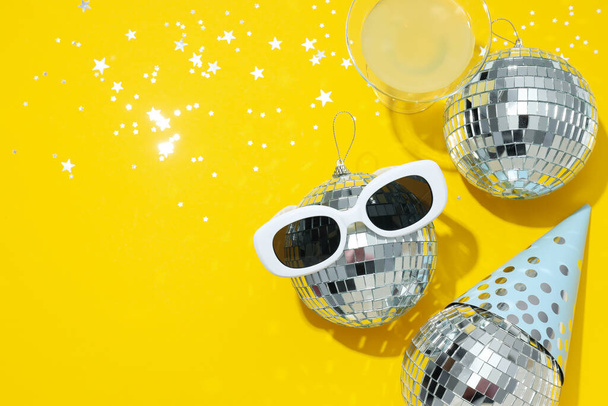 Bolas de discoteca con gafas sobre fondo amarillo - Foto, imagen