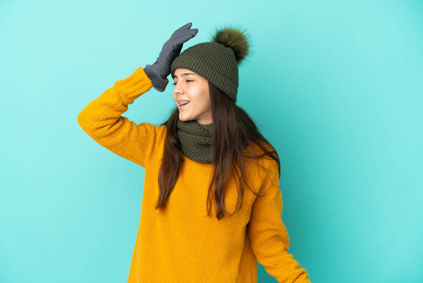 Молодая французская девушка, изолированная на синем фоне с зимней шляпой понял что-то и намереваясь решение - Фото, изображение