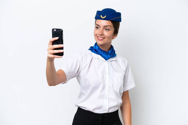 Αεροπλάνο αεροσυνοδός καυκάσιος γυναίκα απομονωμένη σε λευκό φόντο κάνοντας μια selfie - Φωτογραφία, εικόνα