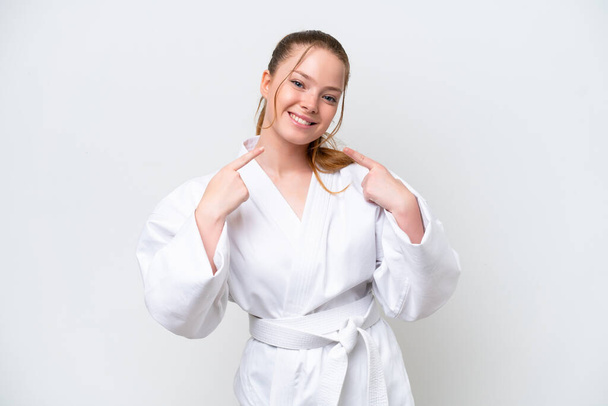 Young caucasian girl doing karate isolated on white background giving a thumbs up gesture - Fotografie, Obrázek