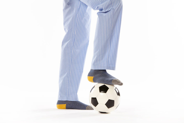 Joven en pijama jugando al fútbol. Detalle de piernas. Ropa de noche - Foto, imagen
