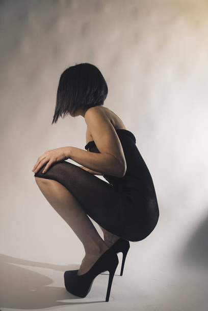 Сексуальна жіноча модель нижньої білизни в студії позує на фото. - Фото, зображення