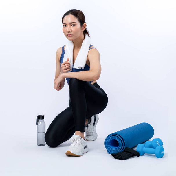 Atletická a sportovní asijská žena odpočívající po intenzivním tréninku kardio cvičení. Zdravé cvičení a fit péče o tělo životní styl pronásledování ve studiu natočil izolované pozadí. Silný - Fotografie, Obrázek