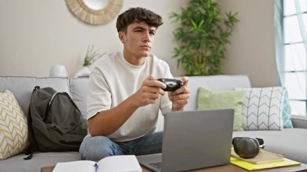 Selbstbewusster junger hispanischer Teenager, ein begeisterter Spieler, der sich zu Hause einem epischen Online-Videospiel hingibt, bequem auf dem Sofa sitzt, den Steuerknüppel in der Hand hält und jeden Sieg feiert! - Filmmaterial, Video