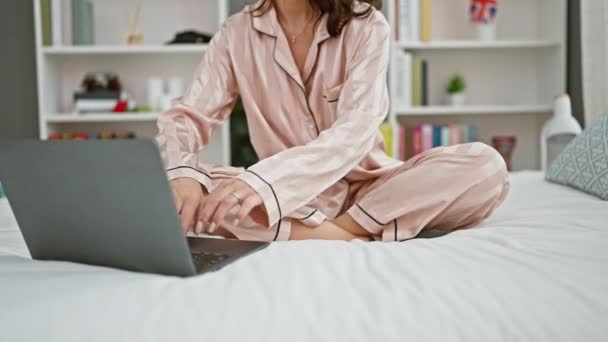 Mladá žena dělá online jóga cvičení sedí na posteli v ložnici - Záběry, video