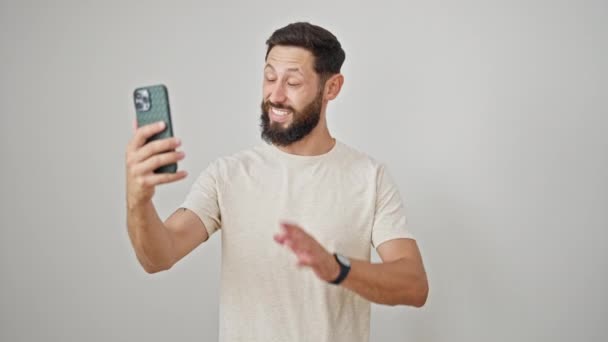 jonge latino man glimlachen zelfverzekerd met video bellen over geïsoleerde witte achtergrond - Video