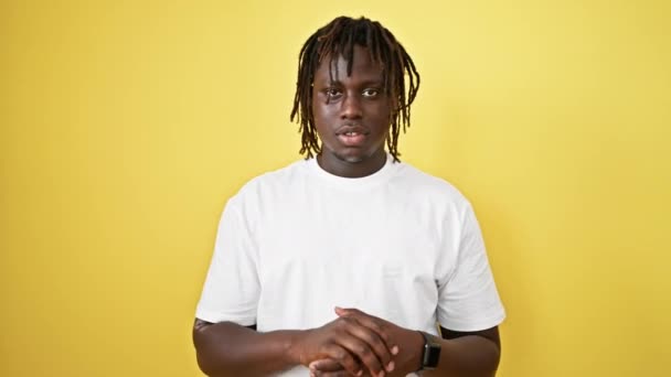 Afro-Amerikaanse man glimlacht zelfverzekerd spreken over geïsoleerde gele achtergrond - Video