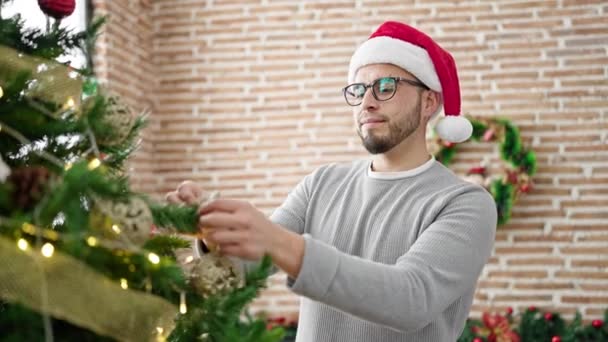 Hombre hispano decorando árbol de Navidad en casa - Metraje, vídeo