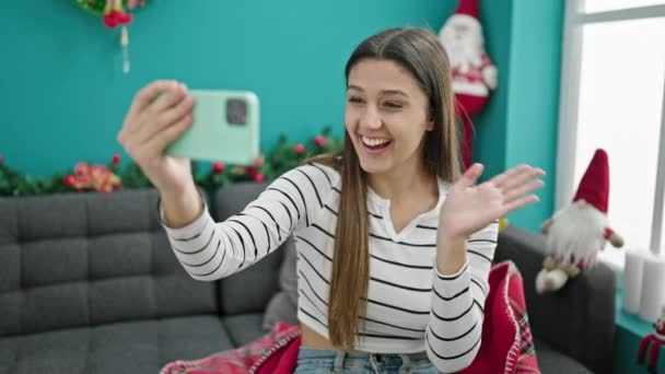 Молода красива іспаномовна жінка робить відеодзвінок, махаючи святкуванням Різдва вдома - Кадри, відео