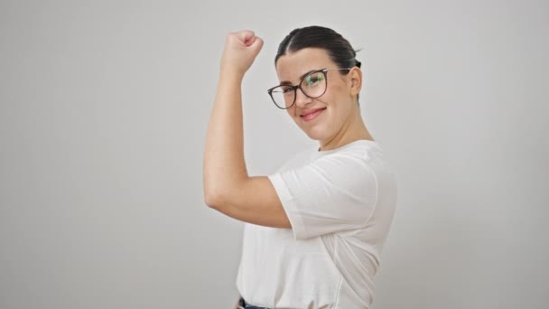 Young beautiful hispanic woman smiling confident doing strong gesture with arms over isolated white background - Footage, Video