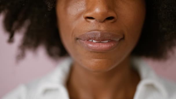 アフリカ系アメリカ人女性は孤立したピンクの背景の上に笑顔を閉じる - 映像、動画