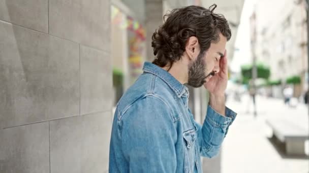 Fiatal spanyol férfi támaszkodik a falra stresszes az utcán - Felvétel, videó