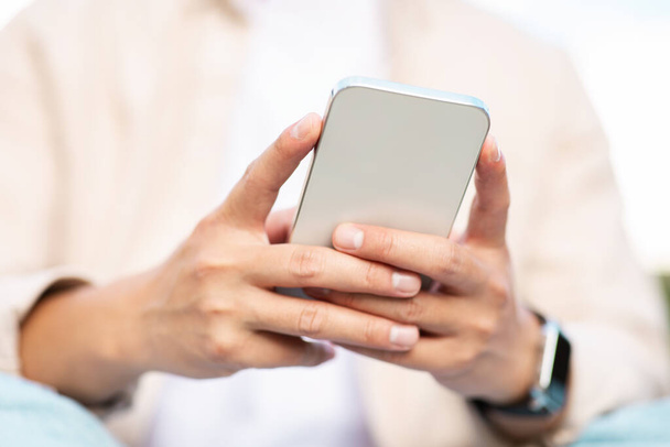Mãos de homem segurando smartphone, empreendedor irreconhecível em roupas casuais usando telefone de chamada, digitação de e-mail, bate-papo, websurf, recortado. Aplicação móvel, comunicação - Foto, Imagem