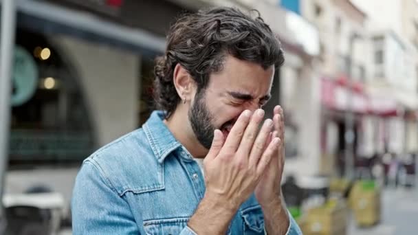 Young hispanic man rubbing the eyes at street - Footage, Video