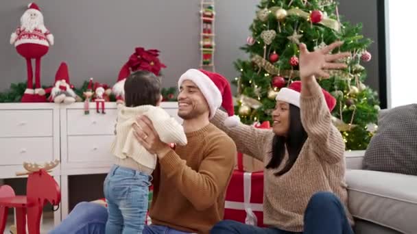 Пара и сын сидят на полу у рождественской елки и играют дома - Кадры, видео