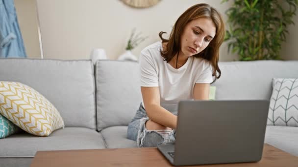 Νεαρή γυναίκα φινίρισμα για να χρησιμοποιήσετε το φορητό υπολογιστή που βρίσκεται στον καναπέ τόνισε στο σπίτι - Πλάνα, βίντεο
