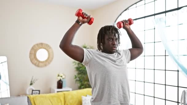 African american man using dumbbells training at home - Footage, Video