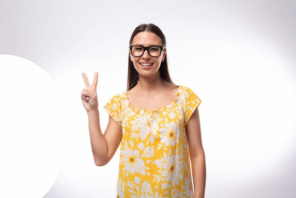attraktive junge Frau mit Brille zur Sehkorrektur im orangefarbenen T-Shirt. - Foto, Bild