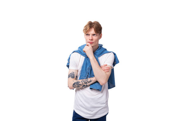 Молодой успешный рыжеволосый парень в голубой рубашке идет на мозговой штурм. - Фото, изображение