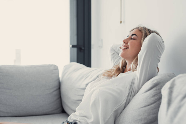 Молодая спокойная женщина охлаждения расслабляющий опираясь на удобный диван дремлет на диване в гостиной отдыха здоровый тихий сон, дыхание свежий воздух, без стресса выходные дома, спокойствие
 - Фото, изображение