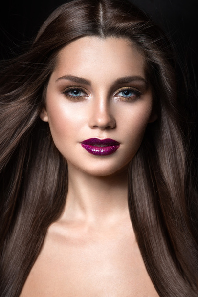 Beautiful girl with golden makeup and burgundy lips with the wind in hair. Beauty face. - Foto, Imagem