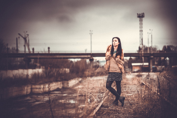 Long hair brunette girl outdoor with old industrial bridge behin - Fotoğraf, Görsel