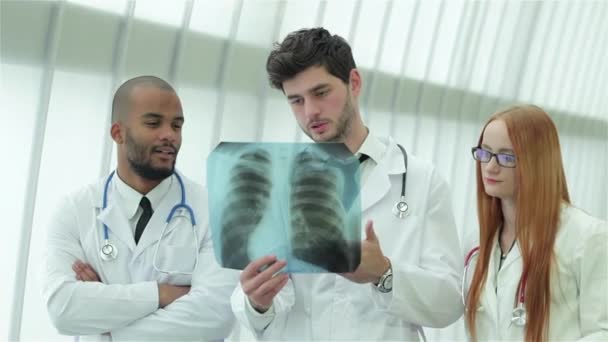 Poumons sains et dangers du tabagisme. Trois médecins confiants examinant un cliché radiographique des poumons
. - Séquence, vidéo