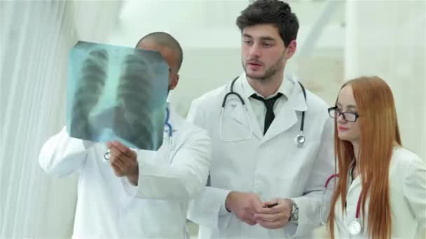 Egészséges tüdő és a dohányzás veszélyei. Három magabiztos orvos vizsgálja röntgen pillanatfelvételt a tüdő. - Felvétel, videó