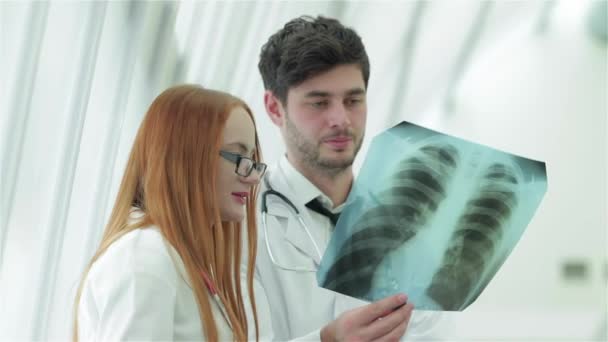 Poumons sains et dangers du tabagisme. Trois médecins confiants examinant un cliché radiographique des poumons
. - Séquence, vidéo