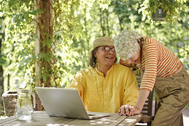 Senior paar buiten met een laptop - Foto, afbeelding